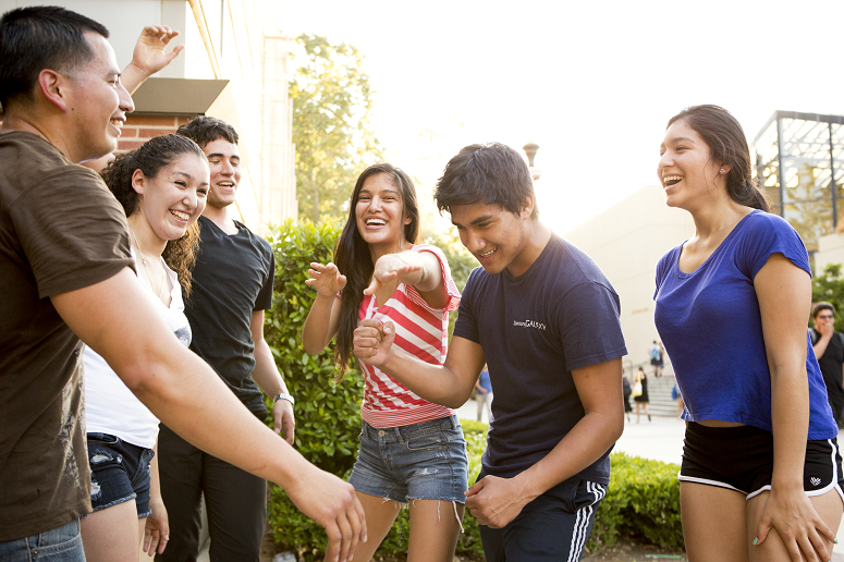 Photo of students laughing while standing near Bruin Bear