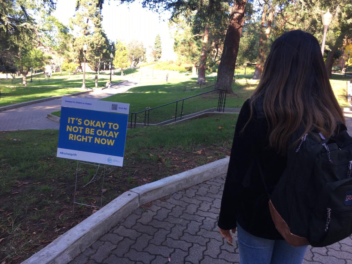 Girl at Bruin Walk looking at a poster